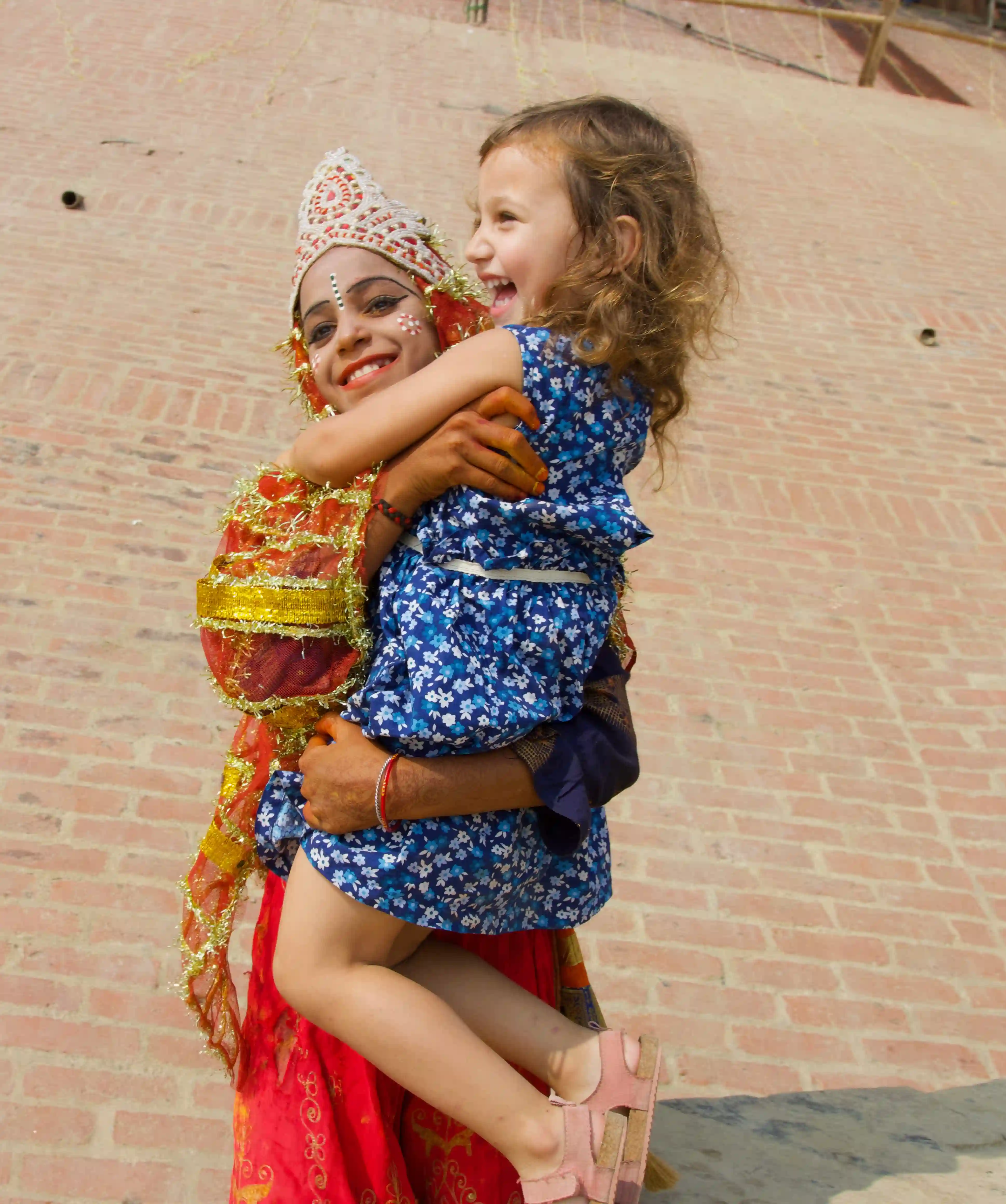 Our daughter hugging an Indian woman in traditional dress — the kind of real human encounter at the heart of worldschooling