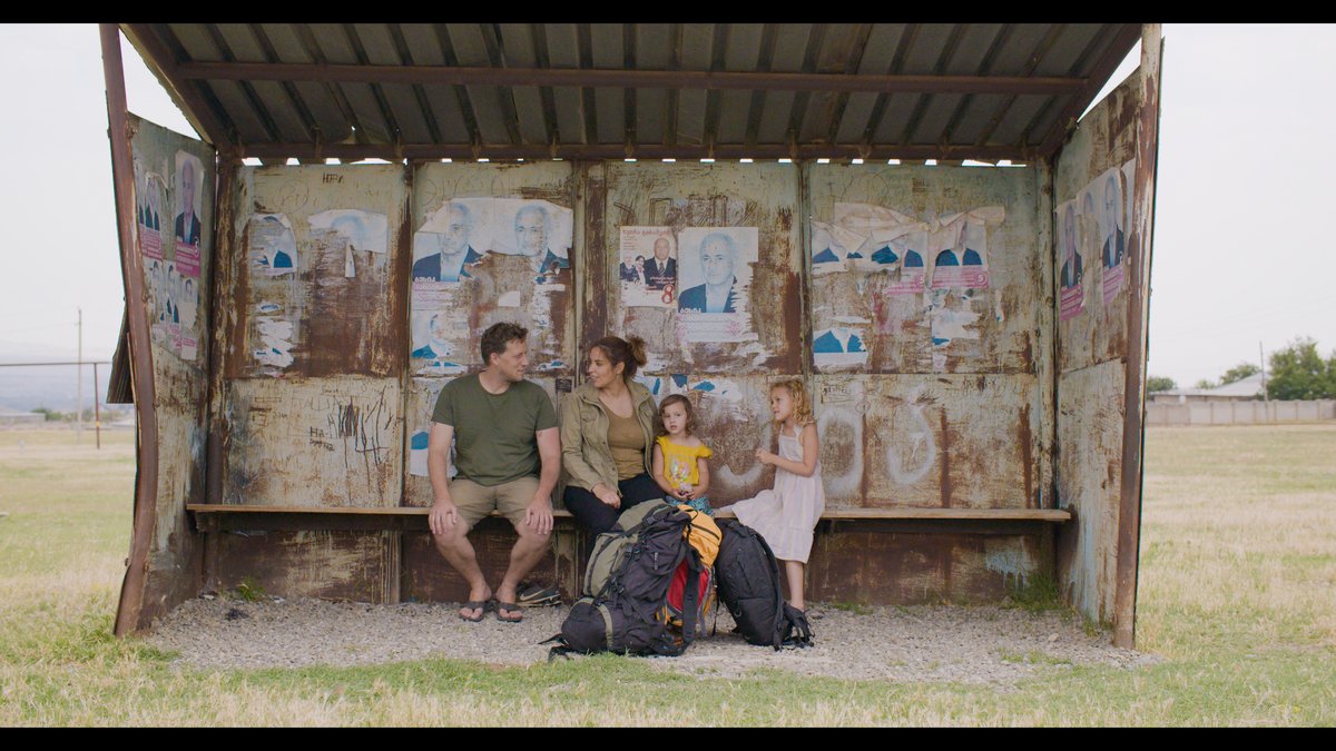 Timo, Salima and their daughters waiting at a bus stop in Georgia — family travel with kids